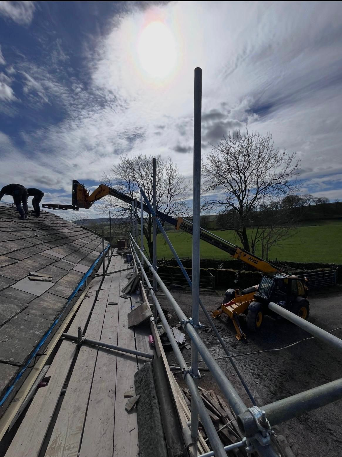 Roofing works with cherry picker on barn