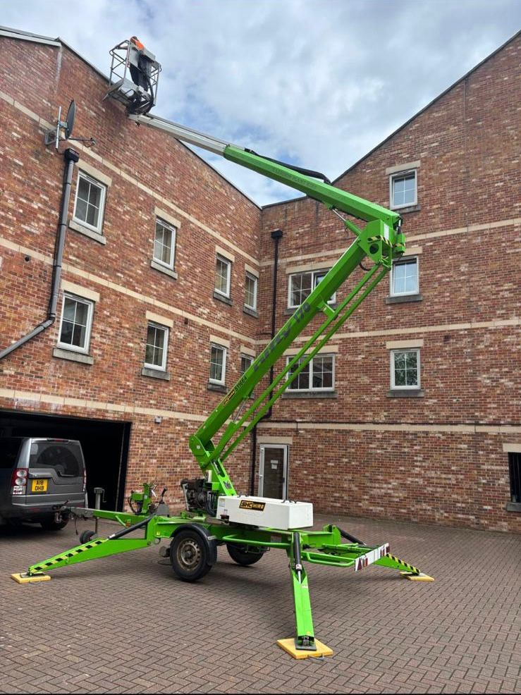 Access platform working on brick apartment building